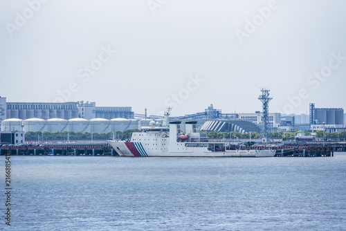 Photography Chinese Maritime Safety Administration vessel berthed at a quay in Shanghai, featuring a white hull and distinctive maritime patrol vessel design