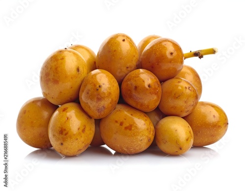 Pile of fresh yellow dates on white