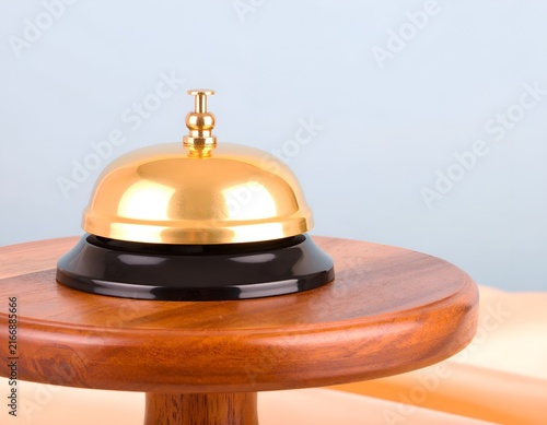 Polished brass bell on tiered black and wood stand