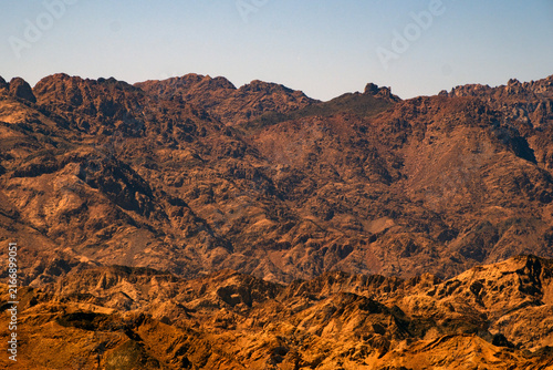 Bild auf Leinwand Rugged desert mountain range landscape with arid terrain and rocky peaks
