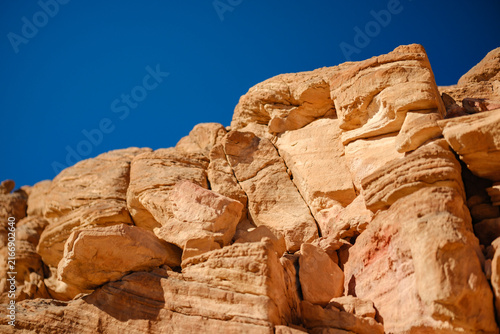 Foto Layered rock strata and sandstone cliff face under blue sky