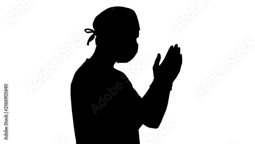 Silhouette of person praying with hands together white background.