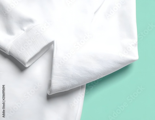 White sweatshirt cuff detail on mint background.