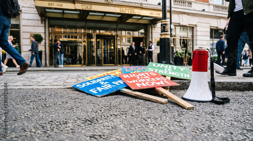 Protest signs and megaphone on street outside hotel entrance