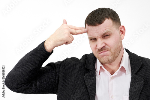 Foto man pointing his finger to his head to shoot himself on a gray background, stres