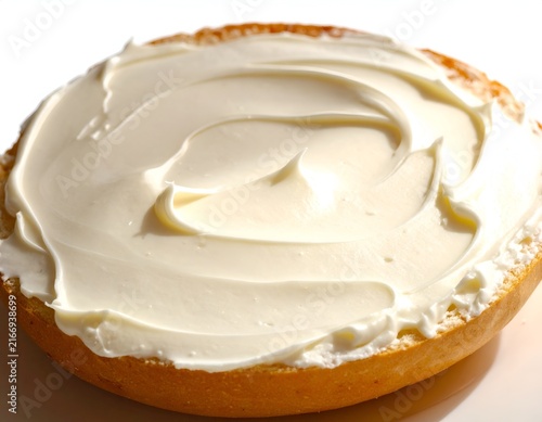 Top view of creamy white spread on bagel