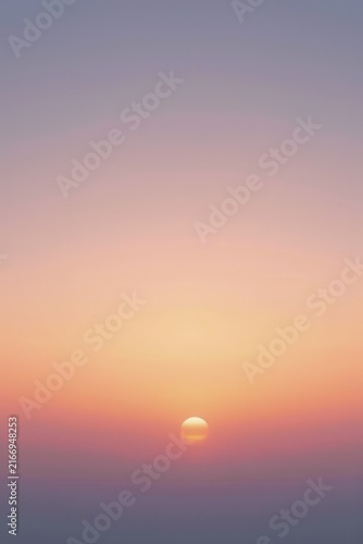 Minimalist sunset scene with glowing sun near horizon, blending warm orange and pink into cooler purple and blue tones, evoking serene twilight atmosphere.