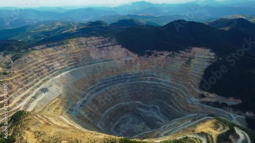 Aerial view of massive open pit copper mine at Rosia Poieni in Alba County, Romania. Massive Terraced Open Pit Mine in the Apuseni Mountains. Human Impact on Nature, Giant Stepped Terraces of Surface 