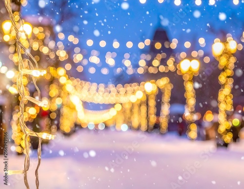 Blurry festive street lights in a snowy winter night.
