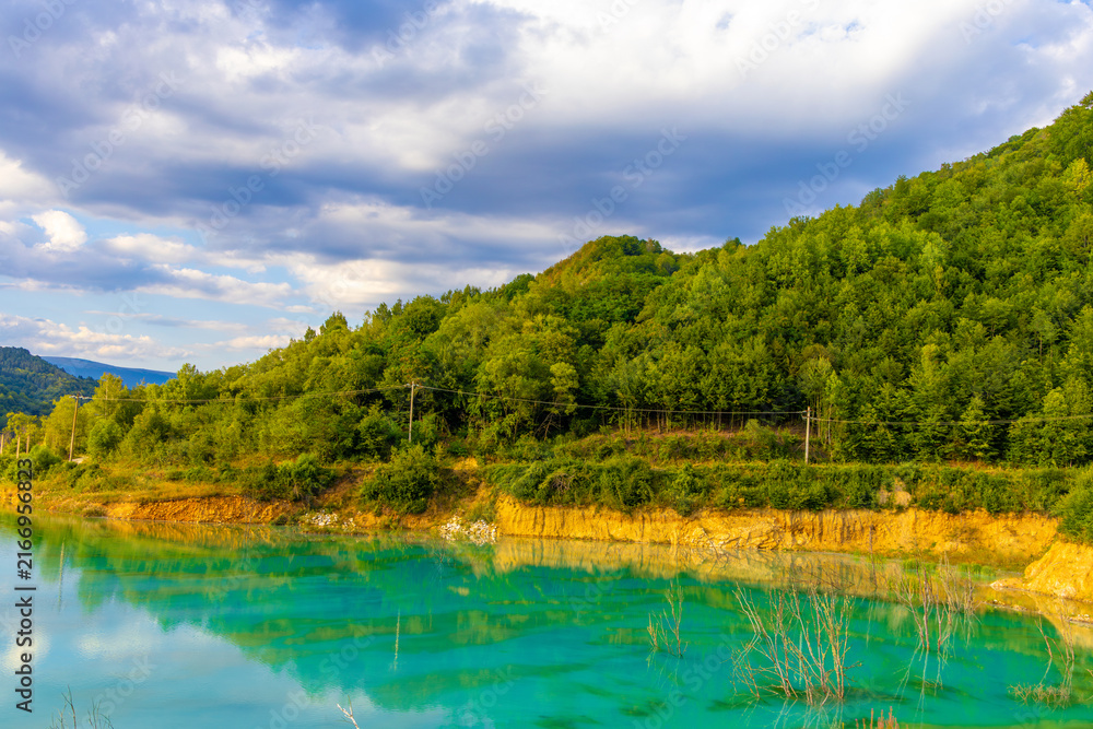 Fototapeta premium Landscape with artificial tailings pond at Geamana Flooded Village in the Apuseni Mountains of Alba County, Romania, dumping ground for toxic waste from the nearby Rosia Poieni copper mine