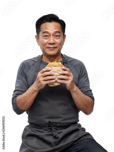 Asian man wearing apron holding a burger isolated on a transparent background