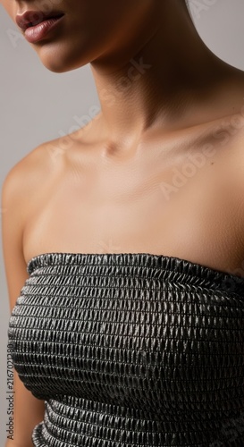 woman with beautiful glowing skin wearing a stylish black tube top dress