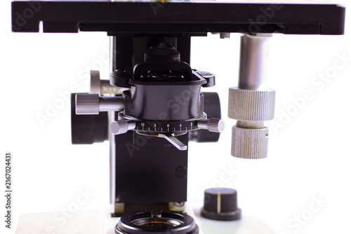 Detailed view of a precision microscope stage with objective lenses, positioning controls and illuminated condenser, designed for accurate specimen observation and analysis.