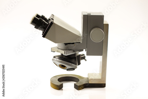 Classic laboratory microscope featuring binocular eyepieces, rotating objective holder, mechanical stage and heavy-duty metal construction for scientific observation.