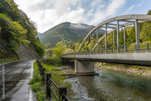Spring mountain road bridge over a clear river