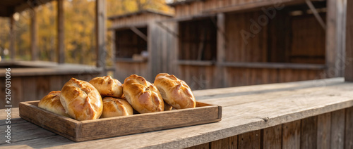 Fresh Baked Pirozhki on Wooden Tray at Rustic Market Stall