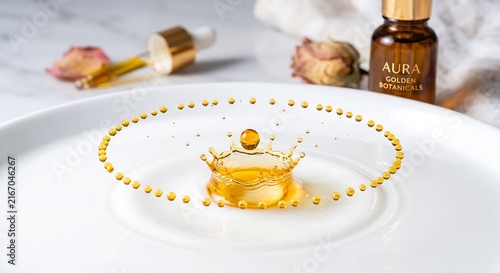 Essential oil drop creating a crown splash with amber liquid serum for skincare routine.