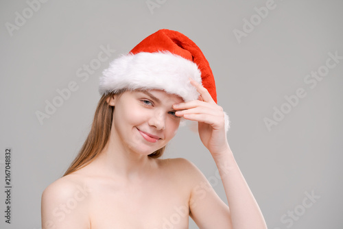 Fotografie Natural Beauty with Clear Skin in a Santa Hat at Christmas