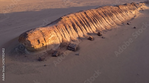 A yardang carved into a streamlined ridge by prevailing wind