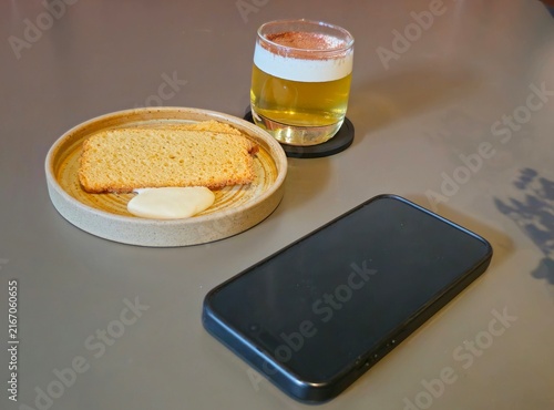 Cuadro en lienzo beer and chips,Golden beer rests beside bread and phone on minimalist table