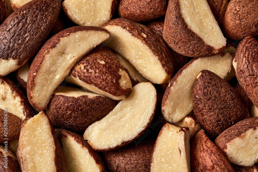 Obraz premium Brazil nuts arranged in a pile showing the brown shells and white inner nuts after being harvested and processed
