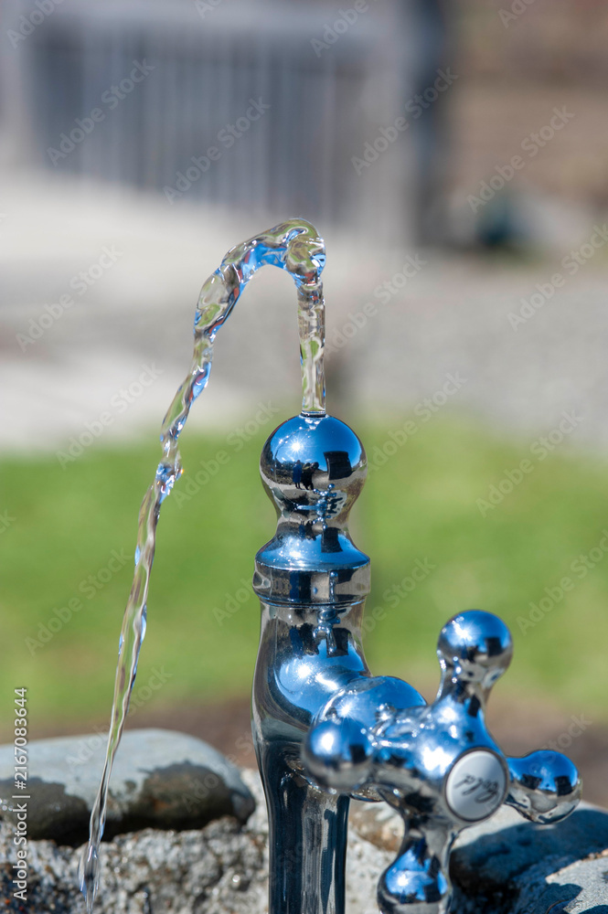 Fototapeta premium Crystal clear water flowing from park drinking fountain for hydration and refreshment