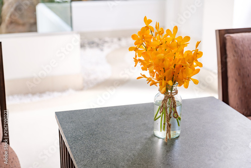 Yellow Orchid Flowers in Glass Vase on Table Close Up