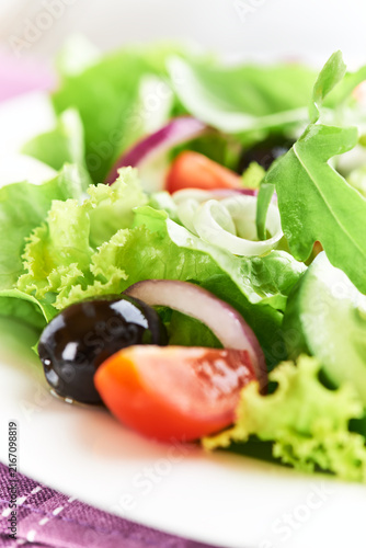 Salad with Olives, Tomatoes and Cucumber on wooden Background. Healthy Snack Idea. Close up