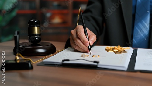 Lawyer signs contract document, legal lawyer reviewing contract terms inside office, finalizing contract settlement near gavel, handling prenuptial agreement, asset division, court approval.