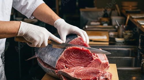 Tapety artystyczne 和食店の厨房で包丁を入れてマグロの解体作業を行う職人の手元
