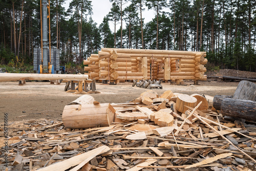 The construction site of a wooden house. Traditional log cabin built from wood logs on sunny summer day. Cottage house design