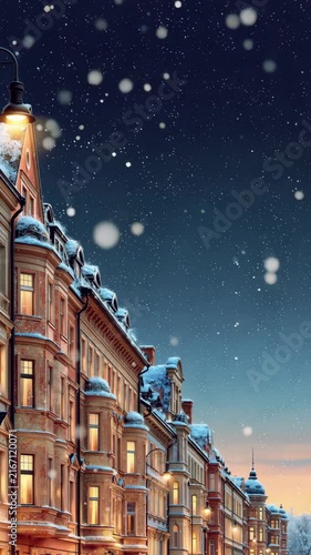 Snow falling over charming European town houses with glowing windows, cozy winter night and Christmas holiday atmosphere