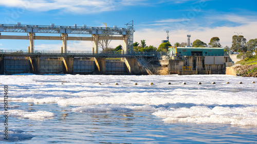 Fotografie Mulwala weir rises above foam covered Murray River