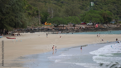 Принти на полотні The image depicts a sandy beach with several people enjoying the shoreline