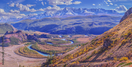 Mountain autumn landscape, river meanders in the valley, snow-capped peaks