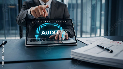 Business professional pointing at audit concept on a digital laptop