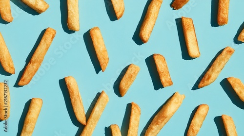 Golden fries, fresh and delicious, served on a bright blue surface.