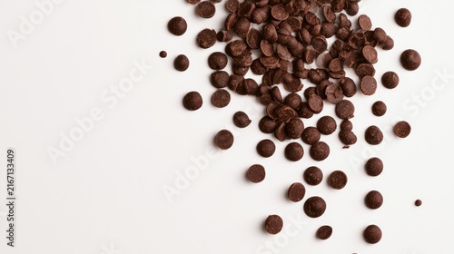 Sweet chocolate bits sprinkled on a clean white surface from above