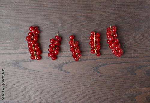 Obraz na płótnie Cluster of red currants rests on a nice wooden surface