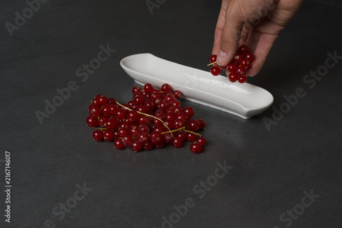 Foto Vibrant red currants rest on a sleek, dark surface