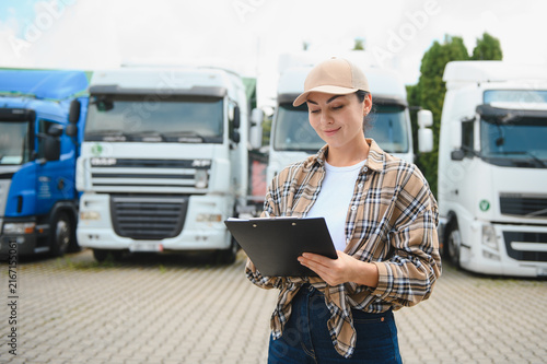 Quadro su tela Female truck driver checking delivery manifest in fleet yard