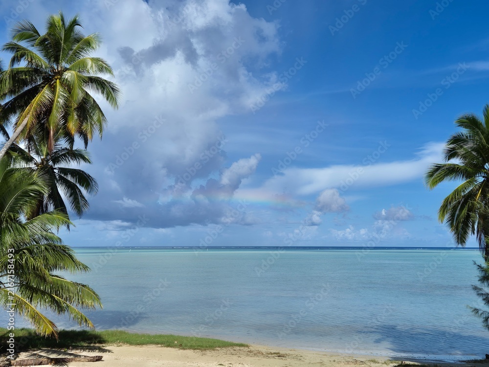 Obraz premium Tropical Lagoon With Palm Trees and Faint Rainbow