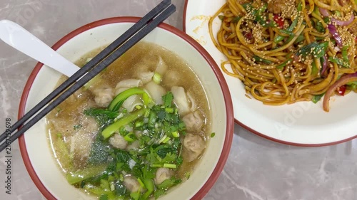 Chinese Restaurant Table with Noodles on Plate and Wonton Soup in Bowl – Traditional Dumplings and Noodle Dish