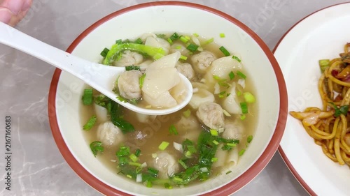 Close Up of Chinese Wontons on Restaurant Table – Traditional Dumpling Soup with Green Onions