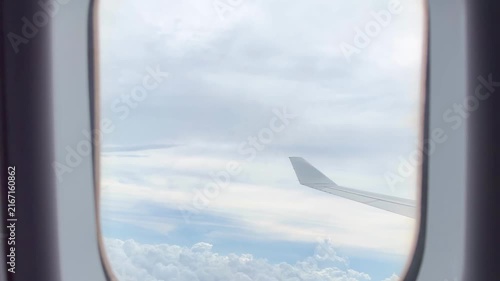 View from Airplane Window Looking Down at Clouds – Aerial Perspective of Fluffy White Clouds Over Blue Sky