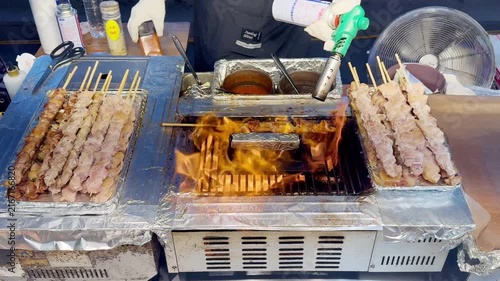Korean Street Food – Grilling Skewers and Beef Steak Over Open Flame at Outdoor Market Stall