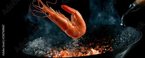 Obraz  z motywem Shrimp cooking in a wok on dark black background