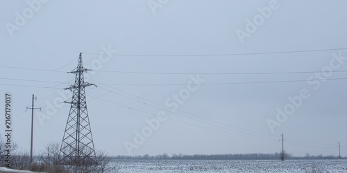Photography High-voltage power transmission pylon in a snowy industrial landscape