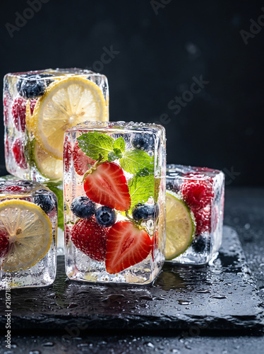High-end conceptual food photography of colorful fruits and berries partially frozen inside transparent blocks of crystal-clear ice 