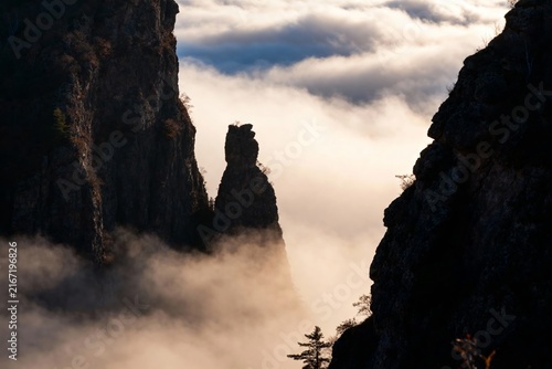 Majestic rock formations rising above a sea of clouds in a mountainous landscape